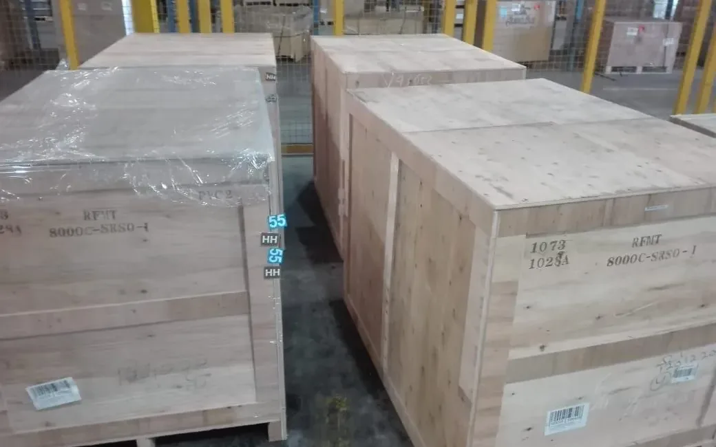 Heavy wooden export crates staged in the bonded warehouse