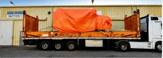 Heavy tarped cargo secured on a flat rack trailer