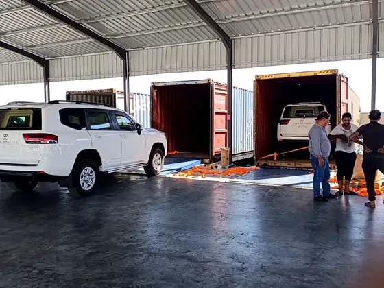 Vehicles positioned and loaded into export containers