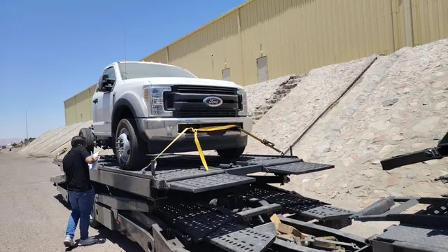Truck chassis secured on a car carrier trailer