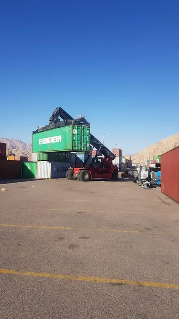 Reach stacker lifting an Evergreen container at the Aqaba terminal