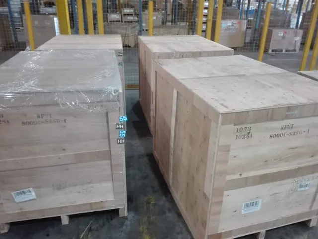 Heavy wooden export crates staged in the bonded warehouse